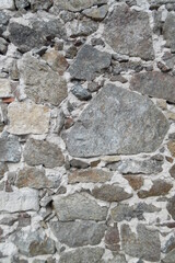 Kunstvoll Tetrislike verbaute Natursteine einer grauen Steinmauer. Unterschiedlich große Steine in Mauer verbaut. Cobblestones mit Zement concept image .