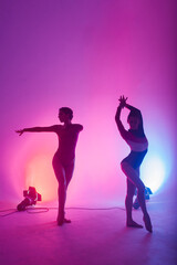 Fototapeta na wymiar The two modern ballet dancers in black and red bodysuit, studio