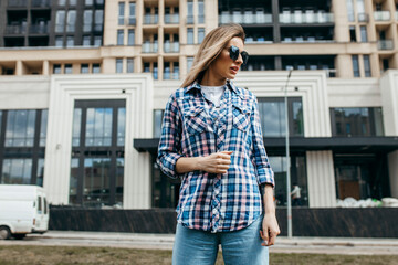 Fashion portrait of beautiful woman with beautiful face, wearing grunge plaid shirt. Posing alone.