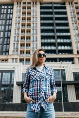 Fashion portrait of beautiful woman with beautiful face, wearing grunge plaid shirt. Posing alone.