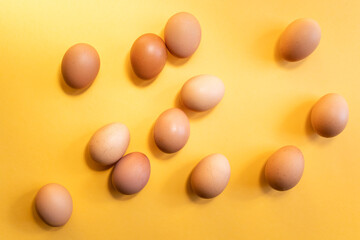 Group of fresh eggs on yellow background. Easter concept.