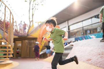 A boy is playing with face masks on playground during quarantine covid-19.