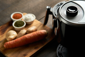 Cooking potatoes and carrot sticks with spices in an air fryer