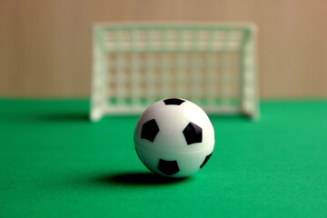 Football. A football in a small gate on a gray background. Mini football. Sports game. The ball is near the gate. Copy the space. Healthy, active outdoor play.