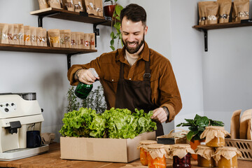 Happy mid farmer man in apron selling fresh produce