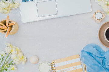 Flat lay home office desktop with laptop, cup of coffee and white flowers on a light background
