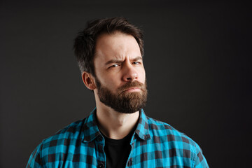 Bearded brooding white man frowning and looking at camera