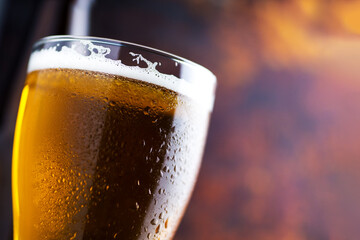 Close-up of light cold beer in water drops on a rusty background