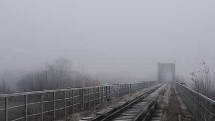 Naklejka premium Heavy fog on the railway bridge, autumn landscape wallpaper