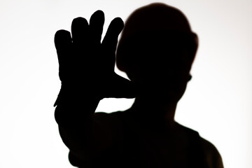 silhouette of construction worker in hardhat showing palm forbidding gesture stop, warning hand sign, protest concept