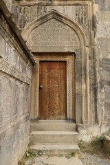 Fototapeta na wymiar An intricately carved wood door leads into the 9th-century church of Surp Poghos-Petros (St. Paul and St. Peter) at Tatev Monastery, Armenia.