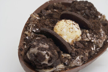 Brazilian Easter dessert. Chocolate egg with cream filling, Brazilian brigadier bonbons, biscuit and sugar. To eat with spoon. 