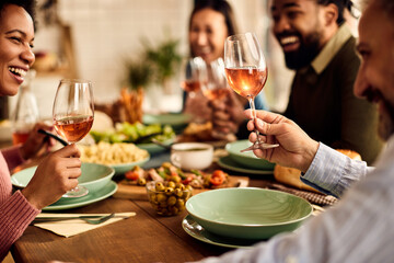 Close-up of happy friends enjoying in wine during lunch at dining table.