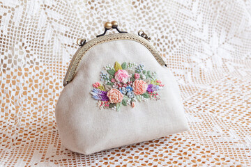 hand-embroidered cosmetic bag on lace background