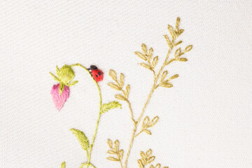 fragment of hand embroidery of meadow flowers