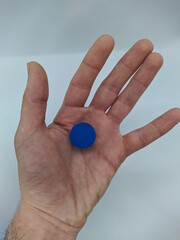 one small blue ball on the palm of your hand on a white background