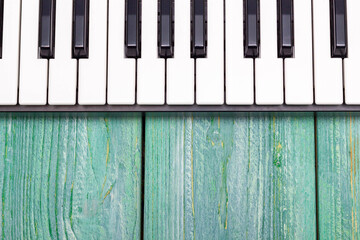 Piano keyboard on a wooden green background