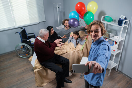 A family visiting a little girl in rehab, they are taking a selfie