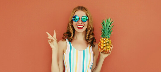 Summer portrait happy smiling woman with pineapple wearing a sunglasses posing on a brown background