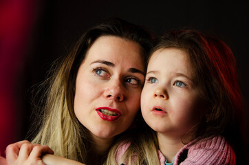 Mother and little daughter close-up. Happy mother with her daughter. The child hugs the mother. Baby hugs. Trusting relationship. Happy parents. Conversation between mother and daughter. Concept