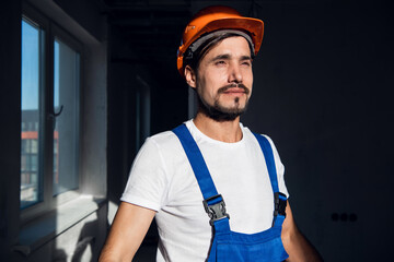 Young engineer puts orange hard hat on his head