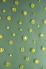 Beautiful vegetable pattern made of fresh light green chili peppers cut into slices on a dark green background. Flat lay creative deisign.