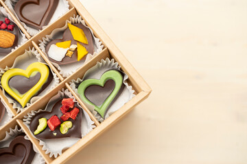 Luxury assorted chocolates hearts in gift box. Handmade candy heart in an open box on white background