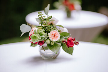 Small arrangement of red flowers for a table for guests at a wedding. Floristic and decoration concept. Close up and best view