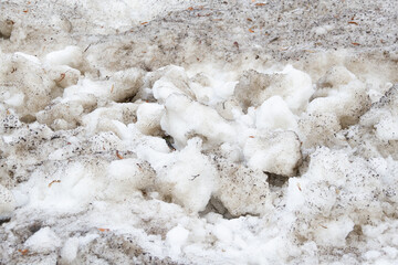 Early spring time dirty gray melted snow with sand pattern texture close-up