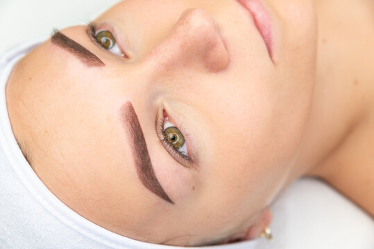 Twarz kobiety świeżo po zabiegu pigmentowania brwi. Makijaż permanentny brwi. Tatuowane brwi trwały makijaż. Salon urody.