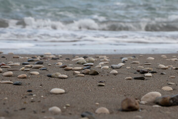 Fototapeta na wymiar stones on the beach and blurred sea in the background