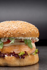 Tasty burger with salmon and vegetables