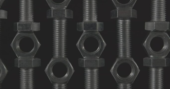 metal nuts and bolts on a black background, decrease