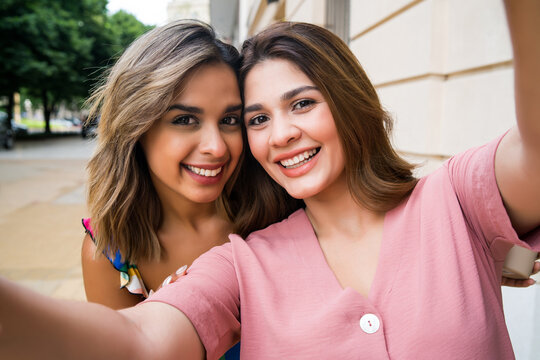 Two friends taking a selfie outdoors.