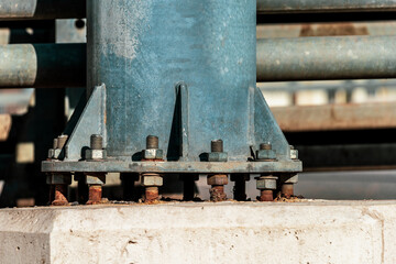 Nuts wrapped in rusty bolts. Street light support.