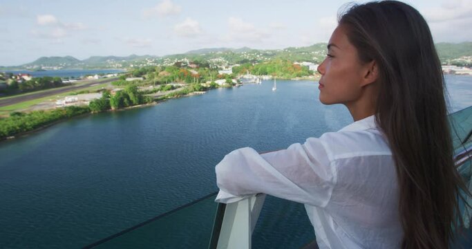 Cruise ship vacation Asian woman relaxing on deck enjoying view from boat of port of call city on St. Lucia island in the Caribbean. Happy casual tourist girl outside on tropical holiday destination.
