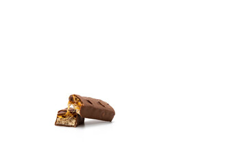 Two pieces of chocolate with nuts, caramel and nougat on a white background