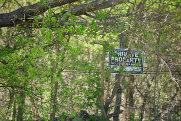 Overgrown Private Property Sign with No Trespassing Notice
