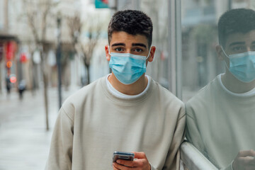 young man with mask and mobile phone