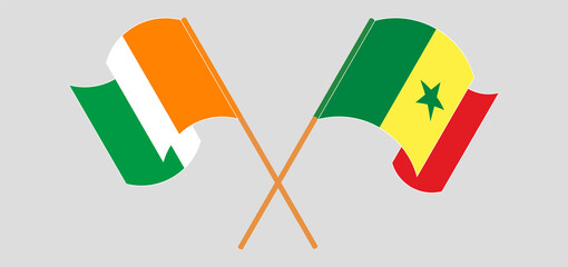 Crossed and waving flags of Republic of Ivory Coast and Senegal