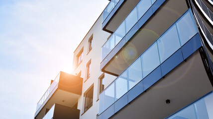Image of condo on afternoon with sun set. Contemporary white residential building against a blue sky. Ideal for illustration of real estate or investment concepts.