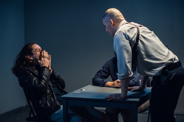 Young police officers are interrogating, the suspect laughs audaciously