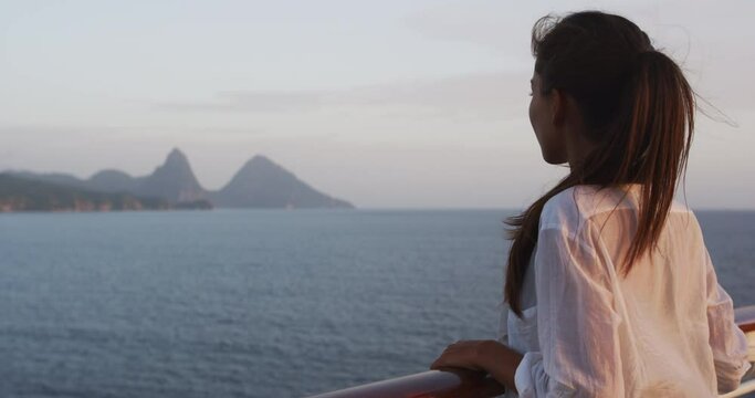 Happy tourist girl having fun on cruise ship by the deux gros pitons, famous attraction in St Lucia. World Heritage site. Young woman on cruise ship vacation travel.
