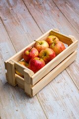 Brazilian apples in a wooden box on a wooden table.