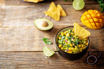 Mango Guacamole with corn chips and ingredients to prepare it