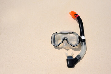 Scuba diving mask with a snorkel on the white sea sand. Diving mask. Photo of a mask and snorkel for swimming in the pool or sea with a central composition on the beach. Scuba diving concept