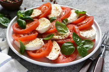 Caprese is a tomato and mozzarella appetizer. Italian salad on the kitchen table with space for the text. 
