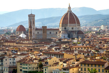 Fototapeta na wymiar Top aerial panoramic view of Florence city with Duomo Cattedrale di Santa Maria del Fiore cathedral, buildings houses with orange red tiled roofs and hills range, blue sky white clouds, Tuscany, Italy