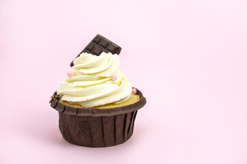 cupcakes with vanilla cream decorated with pink beads on pink background with  copy space for text .