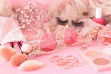 Pink beauty and fashion accessories items on pink background